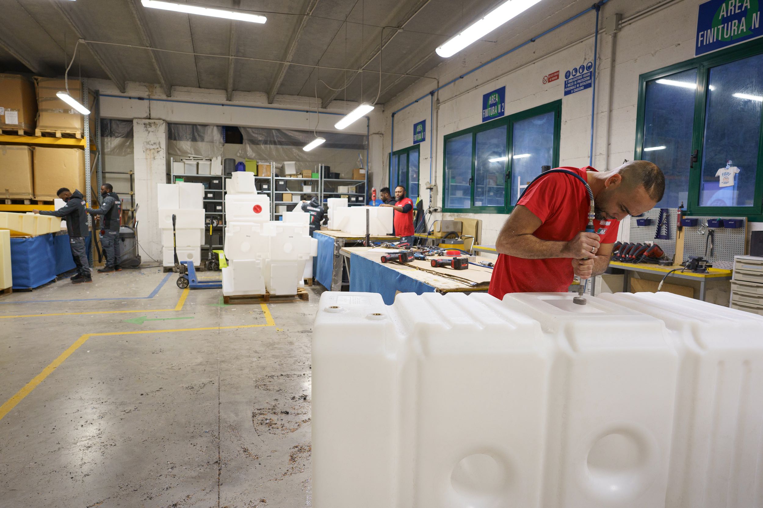 interno di fabbrica con operaio che effettua rifiniture su un termoplastico cavo